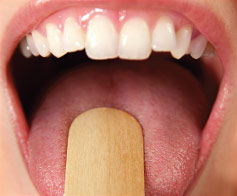 Dentist performs an oral examination.