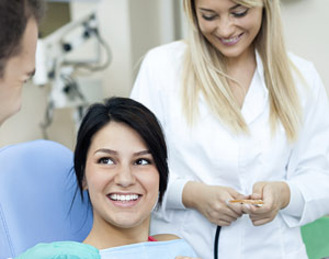 teen girl in dental chair talking to dentist and assistant, cosmetic dentist Edison, NJ 