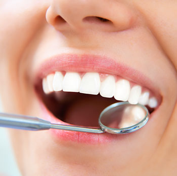 image of a dental mirror being used to inspect a healthy mouth